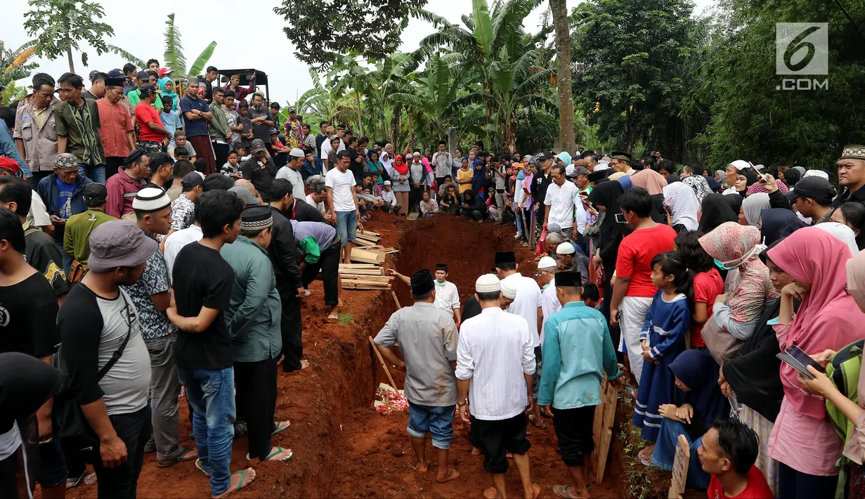 <p>Proses penguburan massal korban kecelakaan bus Tanjakan Emen Subang di TPU Legoso Ciputat, Tangerang Selatan, Banten, Minggu (11/2). Sopir bus maut masih menjalani pemeriksaan intensif. (Liputan6.com/JohanTallo)</p>