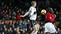 Striker Manchester United, Romelu Lukaku, duel udara dengan bek Fulham, Maxime Le Marchand, pada laga Premier League di Stadion Craven Cottage, London, Sabtu (9/2). Fulham kalah 0-3 dari MU. (AFP/Ian Kington)