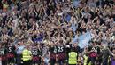 Sejumlah pemain dan penggemar Manchester City merayakan kemenangan 2-1 atas Fulham dalam pertandingan pekan ke-34 Premier League 2022/2023 yang berlangsung di Craven Cottage, Minggu (30/4/2023). Kemenangan tim asuhan Pep Guardiola tersebut berhasil menggeser posisi Arsenal dari puncak klasemen sementara Liga Inggris 2022/2023. (AP Photo/Kin Cheung)