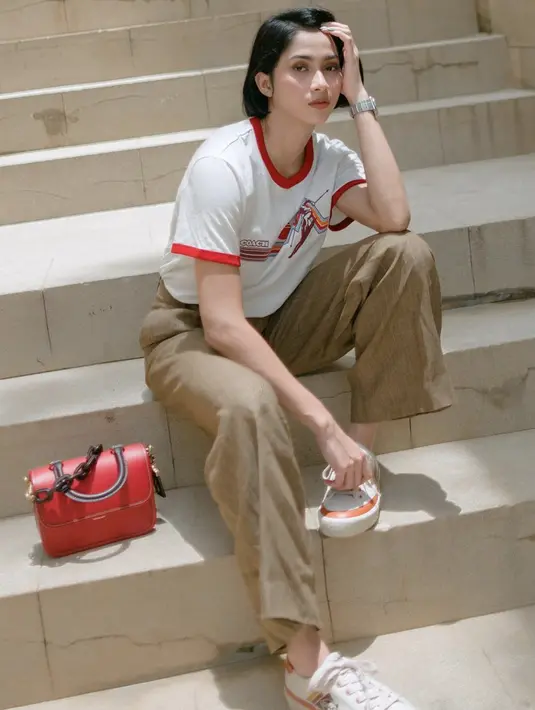 Sneakers menjadi salah satu sentuhan mudah yang bisa ditampilkan untuk gaya sporty. Paduan wide leg pants dan t-shirt menjadi aksen paduan effortless yang menjanjikan.  [Foto: Instagram/ Aghniny Haque]