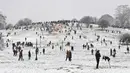 Orang-orang bermain dengan salju di Primrose Hill saat London mengalami hujan salju yang jarang terjadi pada Minggu (24/1/2021). Hujan salju langka di ibu kota Inggris itu membawa kegembiraan di tengah penguncian atau penutupan wilayah (lockdown) secara nasional. (JUSTIN TALLIS/AFP)