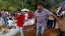 Warga membawa peti jenazah korban banjir dan tanah longsor sebelum dimakamkan di Mocoa, Kolombia, (3/4). Bencana tanah longsor tersebut disebabkan hujan deras yang terus mengguyur sejumlah kawasan di Kolombia. (AP Photo / Fernando Vergara)