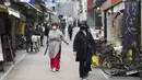Orang-orang dengan masker wajah berjalan melalui jalan perbelanjaan di Tokyo (15/10/2020). Ibukota Jepang mengonfirmasi lebih dari 280 kasus virus korona baru pada hari Kamis. (AP Photo/Hiro Komae)