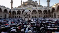 Sejumlah umat muslim Turki melakukan salat Idul Fitridi Masjid Sultan Ahmed, Istanbul, Turki (25/6). Di negara ini, Hari Raya Idul Fitri dikenal dengan sebutan Bayram. (AP Photo / Emrah Gurel)