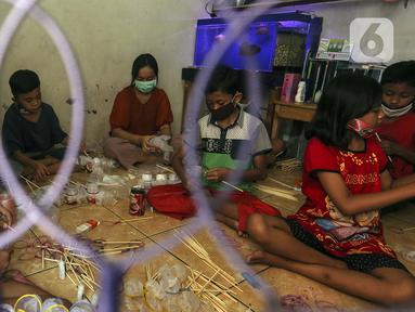 Anak-anak membuat serokan ikan cupang di rumah kontrakan Udin, Sukabumi Selatan, Jakarta Barat, Selasa (22/12/2020). Musim ikan cupang saat ini dimanfaatkan oleh Udin untuk membuat dan menjual serokan ikan seharga Rp 4.000. (Liputan6.com/Johan Tallo)