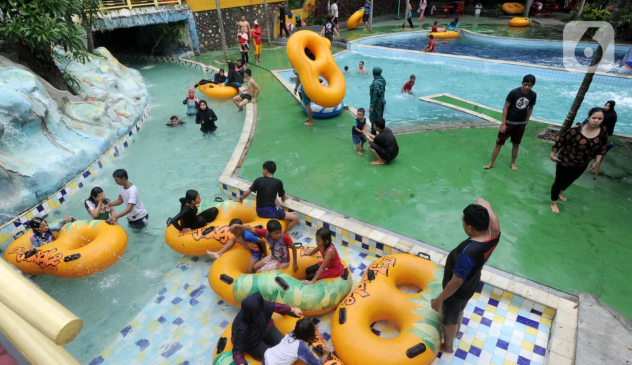 Pengunjung bermain air pada salah satu wahana di The Jungle Waterpark, Bogor, Jawa Barat, Sabtu (18/7/2020). Sejumlah tempat wisata di Kota Bogor mulai hari mulai dibuka kembali setelah selama 4 bulan ditutup dengan menerapkan protokol kesehatan bagi pengunjungnya. (merdeka.com/Arie Basuki)