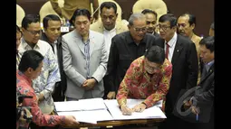 Mendagri Tjahjo Kumolo menandatangi Perppu Pilkada dalam rapat kerja bersama Komisi II DPR di Gedung Nusantara, Kompleks Parlemen Senayan, Jakarta, Senin (19/1/2015). (Liputan6.com/Andrian M Tunay)