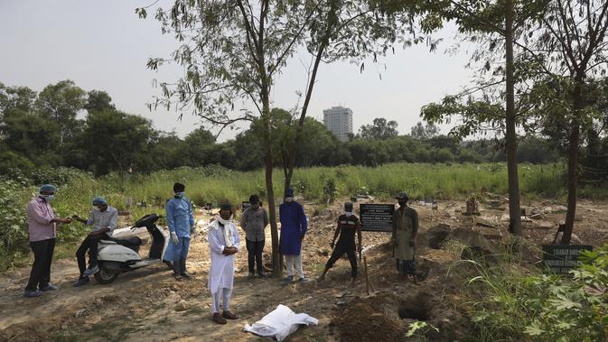 Seorang pendeta berdoa sebelum pemakaman seorang bocah lelaki berusia tiga bulan yang meninggal karena COVID-19 di New Delhi, India, Rabu (16/9/2020). (AP Photo/Manish Swarup)