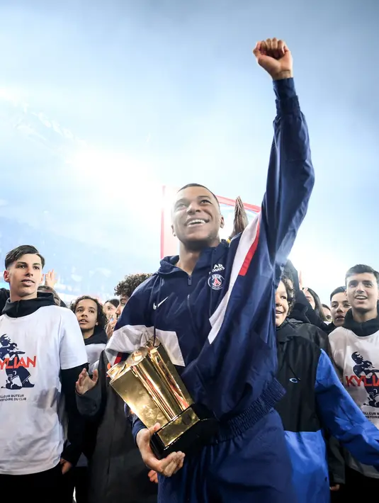 Penyerang Paris Saint-Germain Kylian Mbappe bersorak ke pendukung pada akhir upacara setelah menjadi pencetak gol terbanyak sepanjang sejarah klubnya selepas pertandingan Ligue 1 Prancis antara PSG dan FC Nantes di Parc de Princes, Minggu (5/3/2023) dini hari WIB. Rekor ini berhasil dipecahkan Kylian Mbappe di laga PSG kontra Nantes pada lanjutan Liga Prancis 2022/2023. (FRANCK FIFE / AFP)