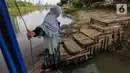 Warga tiba di dermaga usai menggunakan jasa transportasi tradisional, perahu eretan di Banjir Kanal Barat, Jatipulo, Jakarta, Senin (31/01/2022). Perahu eretan yang ditarik tanpa mesin sepi penumpang sejak dibangunnya jembatan penyeberangan dan ramainya moda transportasi. (Liputan6.com/Fery Pradolo)