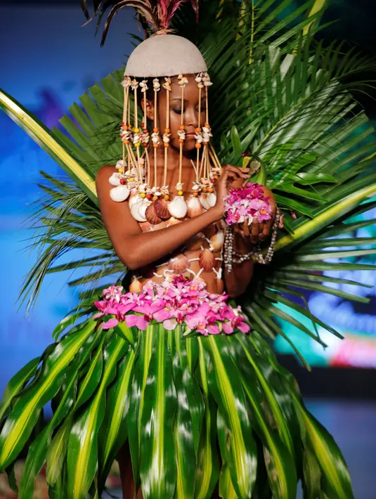 Model berpose di atas catwalk mengenakan busana yang terbuat dari aneka daun dan bunga lengkap dengan aksesoris wajah saat pergelaran Biofashion di Cali, Kolombia (19/11). Aneka warna memeriahkan panggung peragaan tersebut. (Reuters/Jaime Saldarriaga)