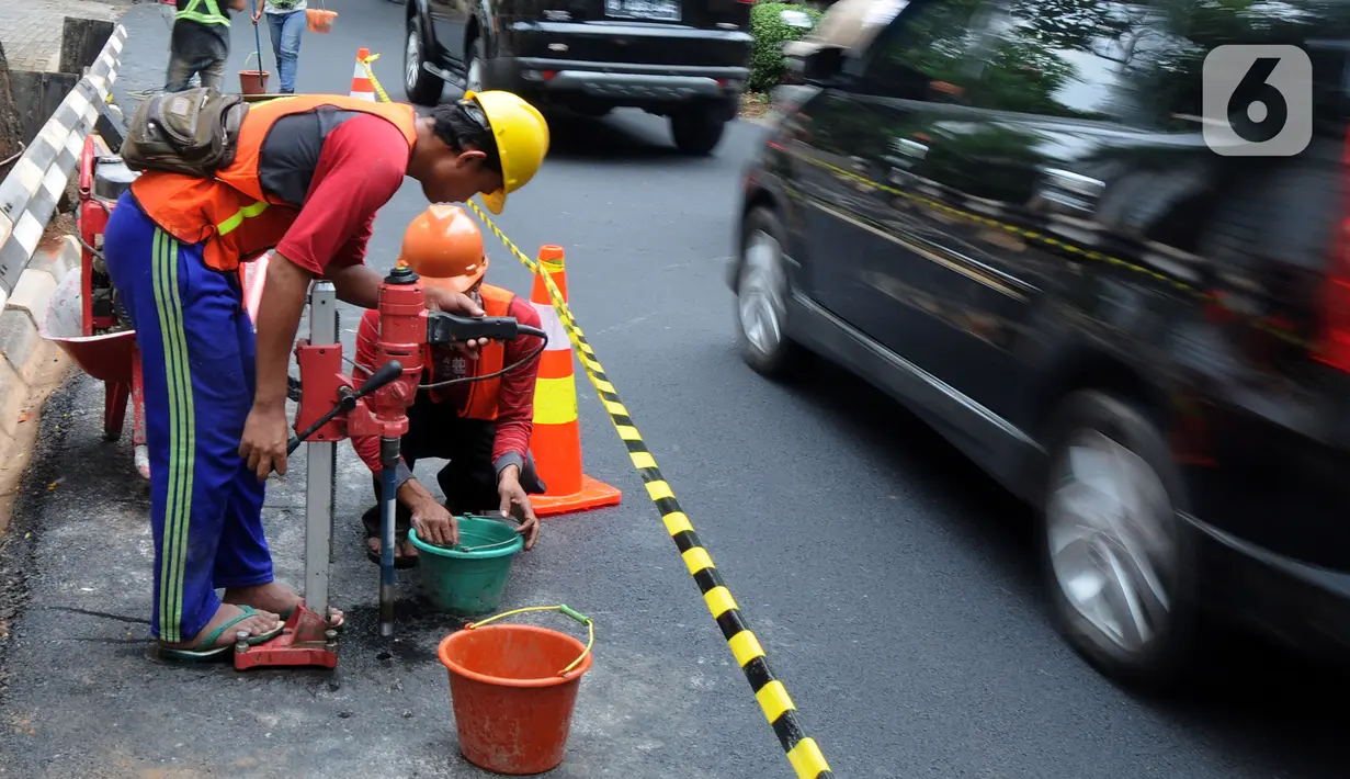 Pekerja mengebor aspal yang menutup sumur resapan di Jalan Lebak Bulus III, Cilandak, Jakarta Selatan, Senin (6/12/2021). Sebanyak 29 sumur resapan yang tertutup aspal kembali dilubangi agar bisa bisa menampung air saat curah hujan tinggi. (merdeka.com/Arie Basuki)