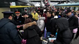 Calon penumpang antre untuk menaiki kereta di sebuah stasiun di Fuyang, Provinsi Anhui, China, Minggu (10/2). Jutaan warga China mulai kembali bekerja setelah menghabiskan liburan Tahun Baru Imlek di kampung halaman. (Chinatopix via AP)