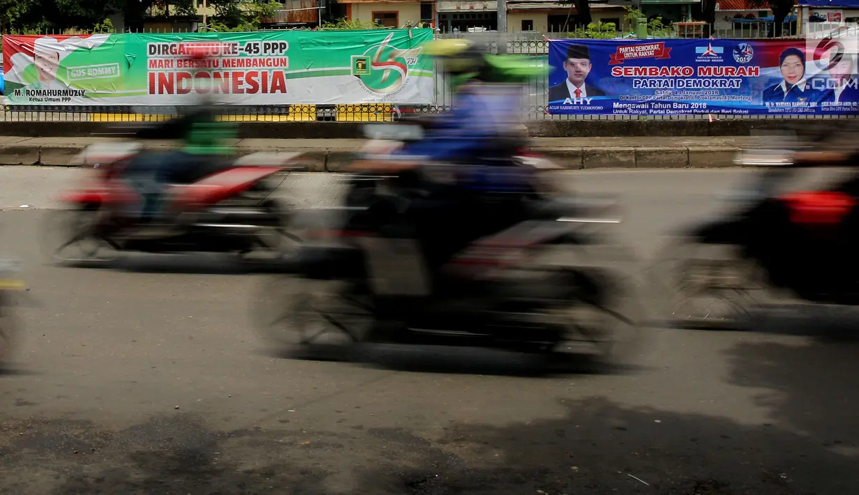 Sejumlah pengendara sepeda motor melintas di depan spanduk partai yang terpampang di Jalan Sultan Agung, Manggarai, Jakarta, Selasa (16/1). Partai politik menawarkan sembako murah hingga melawan korupsi dalam isi spanduknya. (Liputan6.com/JohanTallo)