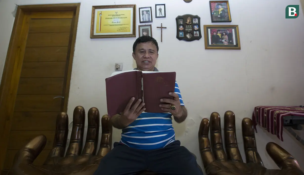 Legenda tinju Indonesia, Ellyas Pical, membaca Alkitab di Kawasan Bintaro, Jumat (13/7/2018). Ellyas Pical adalah petinju Indonesia pertama yang berhasil menjadi juara dunia. (Bola.com/M Iqbal Ichsan)