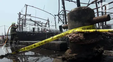 Petugas pemadam kebakaran melakukan pendinginan pada kapal yang hangus terbakar di Pelabuhan Perikanan Samudera Nizam Zachman, Muara Baru, Jakarta, Selasa (5/9/2023). (Liputan6.com/Herman Zakharia)