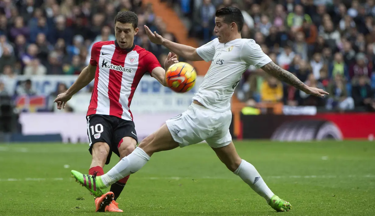 Pemain Athletic Bilbao, Oscar De Marcos (kiri)  berebut bola dengan pemain Real Madrid, James  Rodriguez pada lanjtan La Liga Spanyol pekan ke-24 di Stadion Santiago Bernabeu,  Madrid, Sabtu (13/2/2016).  (AFP / Curto De La Torre)