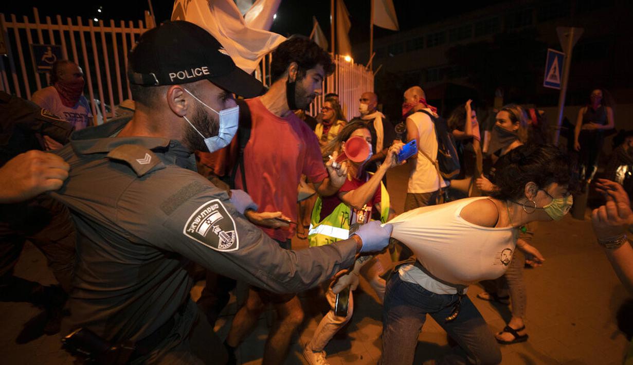 Polisi mencoba menghentikan seorang pengunjuk rasa selama demonstrasi menentang tindakan lockdown di Tel Aviv, Israel, Kamis (1/10/2020). Pengunjuk rasa meyakini lockdown ditujukan untuk mengekang protes terhadap Perdana Menteri Israel Benjamin Netanyahu. (AP Photo/Sebastian Scheiner)