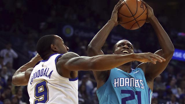 Andre Iguoadala menjaga pemain Hornets Treveon Graham