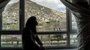 Tarawat, seorang gadis berusia 17 tahun yang telah berhenti sekolah, melihat keluar dari jendela kamarnya, di Kabul, Afghanistan, pada Sabtu, 25 Maret 2023. (AP Photo/Ebrahim Noroozi)