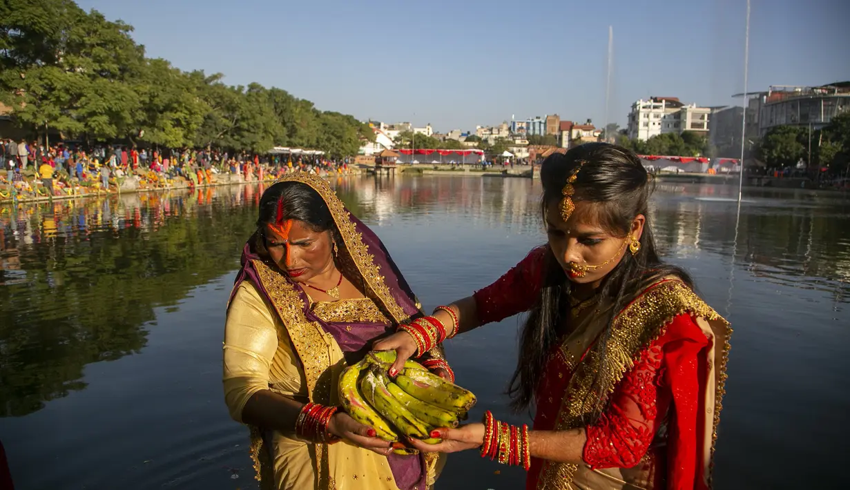 Wanita Nepal berdoa kepada matahari terbenam di kolam Kamal selama festival Chhath Puja di Kathmandu, Nepal, Rabu (10/11/2021). Selama Chhath, sebuah festival Hindu kuno, ritual dilakukan untuk berterima kasih kepada Dewa Matahari karena telah menopang kehidupan di bumi. (AP Photo/Niranjan Shrestha)