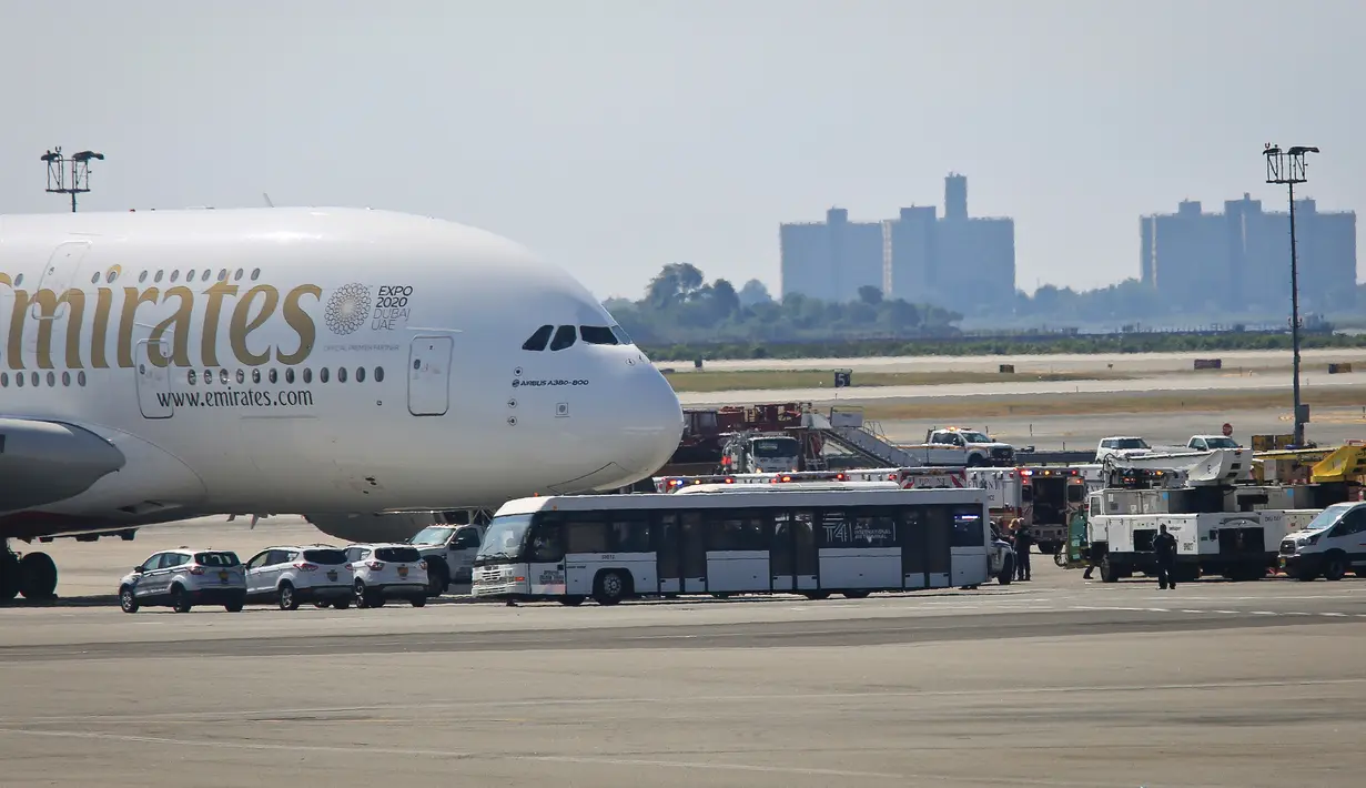 Petugas tanggap darurat berkumpul di luar pesawat setelah penumpang Emirates Airline dilaporkan jatuh sakit di Bandara Kennedy New York, Rabu (5/9). Sekitar 100 dari total 500 penumpang pesawat dari Dubai itu mengeluh sakit dan demam. (AP/Bebeto Matthews)