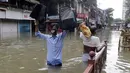 Orang-orang berjalan melewati jalan yang tergenang air setelah hujan lebat di Mumbai, India, Rabu (23/9/2020). Musim hujan di India berlangsung dari Juni hingga September. (AP Photo/Rajanish Kakade)