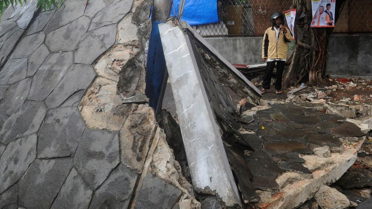Sementara kondisi fisik tembok sebelum roboh memang sudah ada retakan di beberapa sisi.<br><br>Hal tersebut diungkap oleh Andre seorang pengemudi ojek online (ojol) yang menjadi saksi mata kejadian.<br>( Foto merdeka.com / Arie Basuki )<br>
