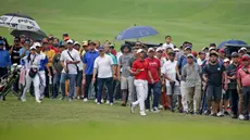 Ratusan penonton dengan setia mengikuti aksi Naraajie Emerald Ramadhan Putra (tengah) pegolf amatir Indonesia berusia 19 tahun yang sempat memimpin perolehan skor di turnamen golf pro BRI Indonesia Open 2019, Minggu (1/9/2019). (Bola.com/Peksi Cahyo)