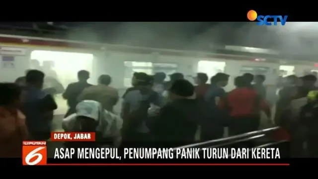 Asap cukup tebal mengepul di KRL jurusan Bogor saat berada di Stasiun Depok, Rabu (5/12) malam. Penumpang yang panik segera berhamburan keluar.