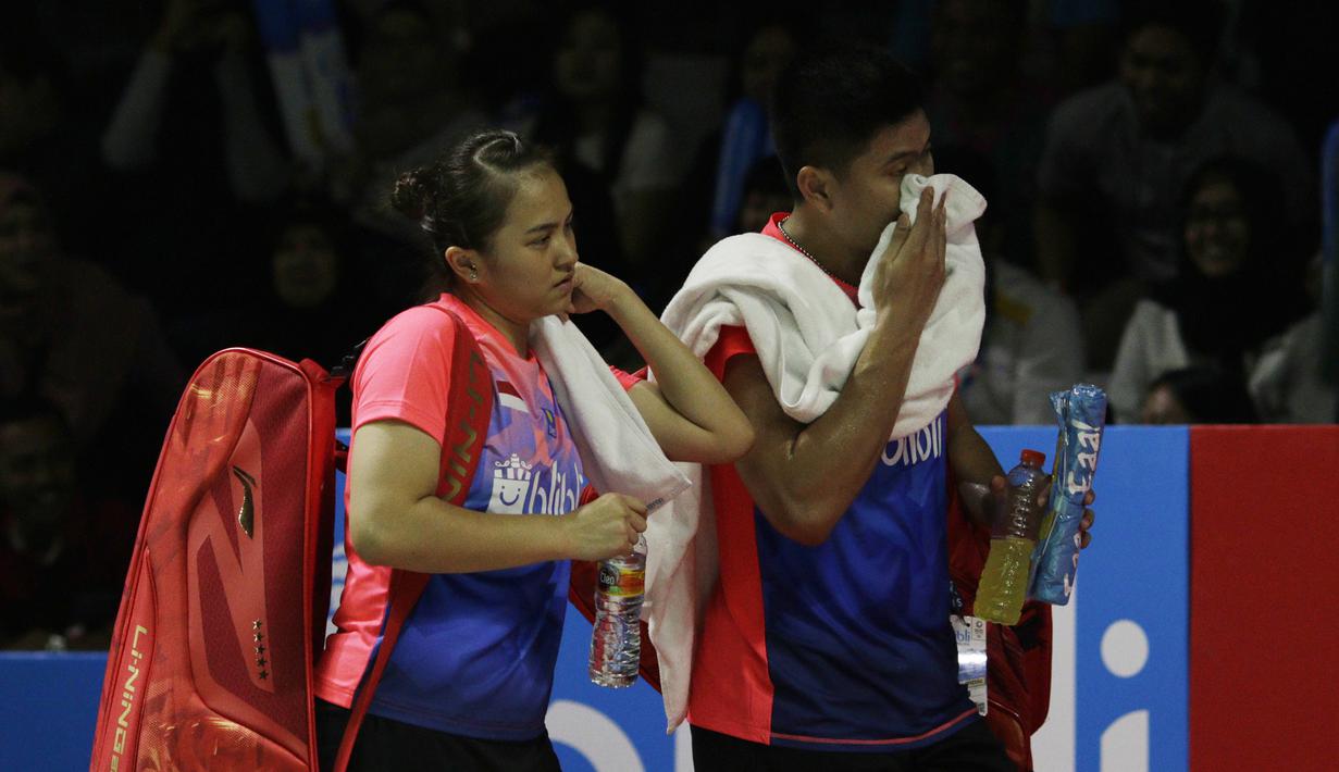 Pasangan Indonesia, Praveen Jordan/Melati Oktavianti, meninggalkan lapangan usai takluk dari wakil Jerman, Mark Lamsfuss/Isabel Herttrich pada Indonesia Open 2019 di Istora, Selasa (16/7). Indonesia takluk 20-22, 14-17. (Bola.com/M Iqbal Ichsan)