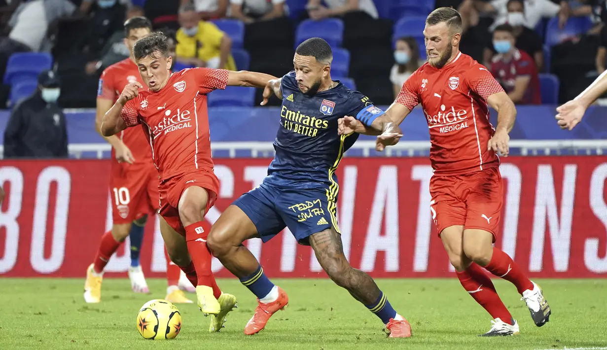 Penyerang Lyon, Memphis Depay, berebut bola dengan pemain Nimes pada laga lanjutan Liga Prancis di Stadion Groupama, Sabtu (19/9/2020) dini hari WIB. Lyon bermain imbang 0-0 atas Nimes. (AP Photo/Laurent Cipriani)