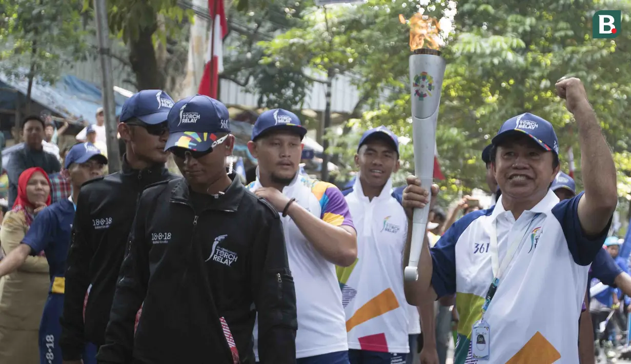 Legenda tinju Indonesia, Ellyas Pical, saat pawai obor Asian Games 2018 di Bogor, Jawa Barat, Selasa (14/8/2018). Api obor yang datang dari Cianjur itu langsung diarak mengelilingi jalanan protokol Kota Bogor. (Bola.com/Reza Bachtiar)
