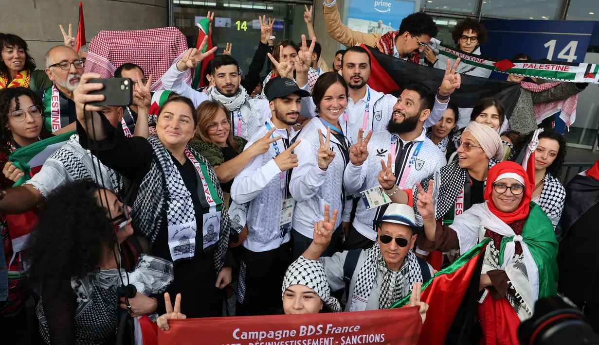 Para atlet Olimpiade Palestina dan anggota delegasi berpose dengan para pendukungnya setibanya di Bandara Charles-de-Gaulle, Roissy-en-France, sebelah utara Paris, pada 25 Juli 2024. (Ahmad GHARABLI/AFP)