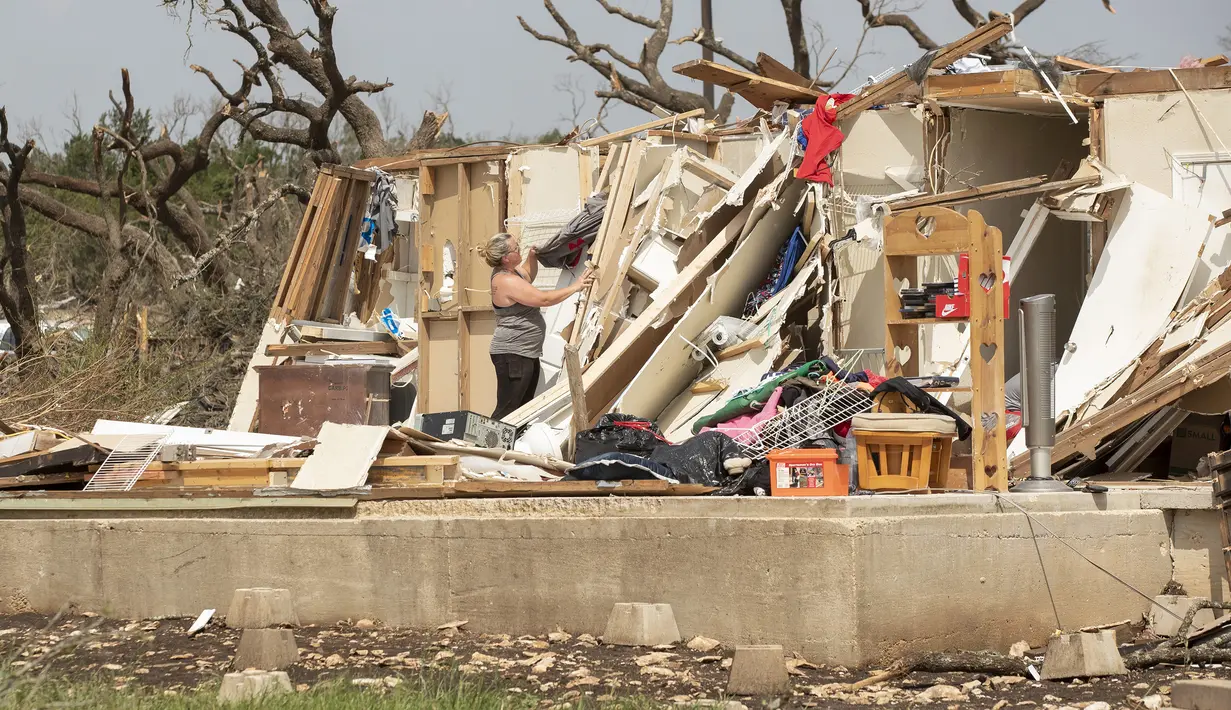 Amanda Lopez, dari McGregor, menyelamatkan barang-barang dari rumah temannya Michelle Light, sehari setelah tornado menghancurkan rumah di FM 2843 dan Cedar Valley Road dekat Salado, Texas (13/4/12). (Jay Janner/Austin American-Statesman via AP)