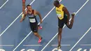 Usain Bolt dan Andre de Grasse mengobrol saat berada di dekat garis finish pada semifinal lari 200 meter pria di Rio de Janeiro, Brasil (17/8). Usain Bolt meraih medali emas kedua di lari 200 meter pria. (REUTERS/Fabrizio Bensch)