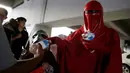Anggota klub penggemar Star Wars, berkostum Emperor's Royal Guard, membagikan botol air ke keluarga pasien selama perayaan Star Wars Day di luar rumah sakit di Monterrey, Meksiko, Rabu (4/5).(REUTERS/Daniel Becerril)
