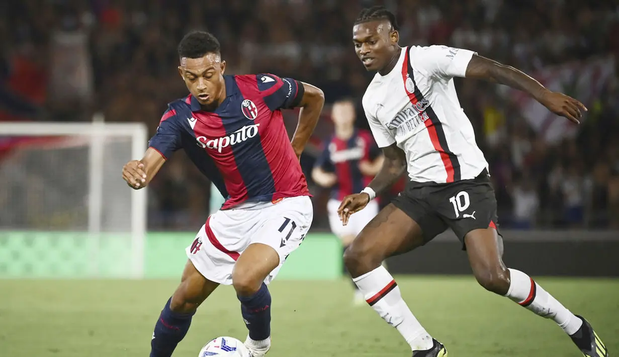 Pemain AC Milan, Rafael Leao, berebut bola dengan pemain Bologna, Dan Ndoye, pada pekan pertama Serie A di Stadion Renato Dall'Ara, Selasa (22/8/2023). AC Milan menang dua gol tanpa balas. (Massimo Paolone/LaPresse via AP)
