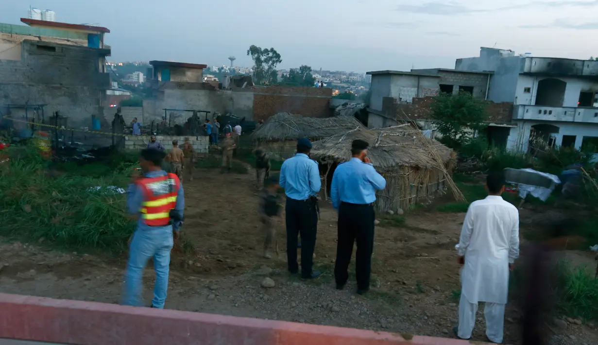Pejabat militer Pakistan memeriksa lokasi kecelakaan pesawat di Rawalpindi, Pakistan, Selasa (30/7/2019). Penyebab kecelakaan belum ditentukan. (AP Photo/Anjum Naveed)