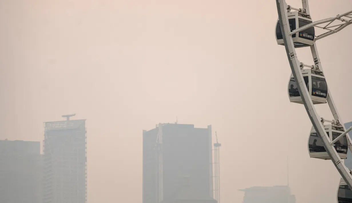 Environment Canada mengeluarkan peringatan kabut asap di beberapa wilayah Quebec karena kebakaran, dengan mengatakan, "konsentrasi tinggi partikel halus menyebabkan kualitas udara yang buruk dan jarak pandang yang berkurang," dengan kondisi yang akan terus berlanjut hingga Senin pagi. (ANDREJ IVANOV / AFP)