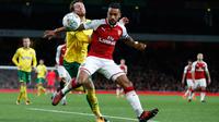 Pemain Arsenal, Theo Walcott berebut bola dengan pemain Norwich City, Angelina pada lanjutan Piala Liga Inggris di Emirates Stadium, Rabu (25/10). Edward Nketiah memborong gol Arsenal saat mengalahkan Norwich City 2-1. (AP/Alastair Grant)