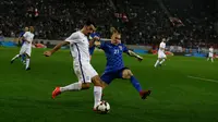 Pemain Yunani, Lazaros Christodoulopoulos berebut bola dengan pemain Kroasia, Domagoj Vida pada laga leg kedua play-off Piala Dunia 2018 di Stadion Karaiskakis, Senin (13/11). Kroasia menang dengan agregat 4-1 atas Yunani. (AP/Thanassis Stavrakis)