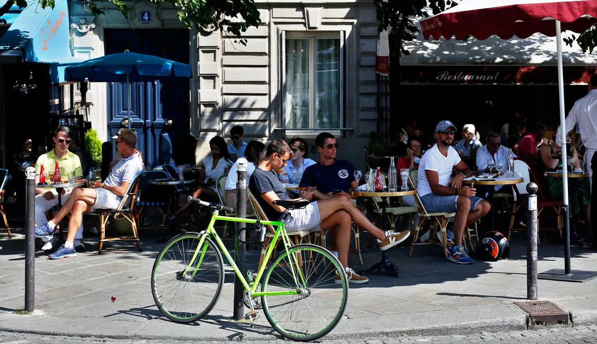 Orang-orang duduk di teras kafe di Paris pada Selasa (2/6/2020). Balai Kota Paris mengizinkan pembukaan area tempat duduk area luar (outdoor) kafe, tetapi di dalam ruangan akan tetap tertutup bagi pelanggan sampai setidaknya 22 Juni mendatang. (AP Photo/Thibault Camus)