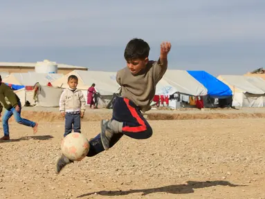 Sejumlah anak pengungsi Irak asyik bermain sepakbola di kamp Khazer, Irak (5/12). Mereka melarikan diri akibat konflik peperangan antara pasukan koalisi Irak dengan ISIS. (REUTERS / Alaa Al-Marjani)