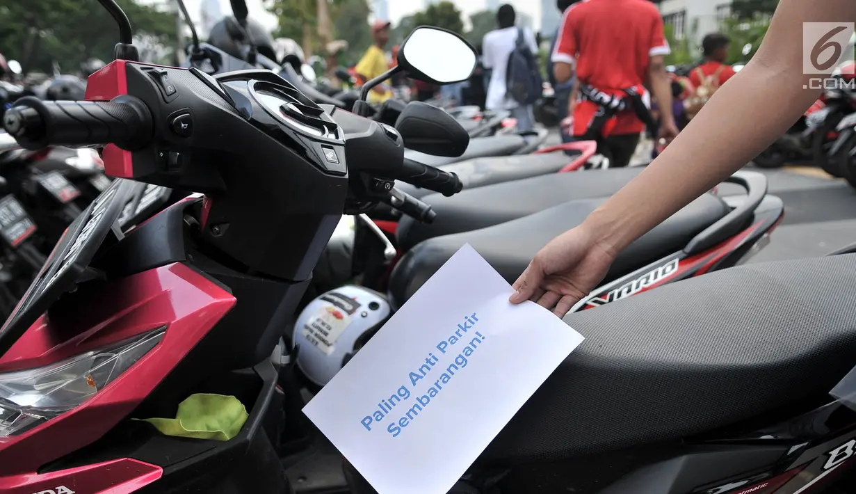 Koalisi Pejalan Kaki membawa poster saat menggelar aksi Tamasya Trotoar Kita di lokasi parkir liar sepanjang jalur pedestrian GBK, Jakarta, Minggu (9/12). Aksi tersebut menyuarakan pengembalian fungsi trotoar. Merdeka.com/Iqbal S. Nugroho)
