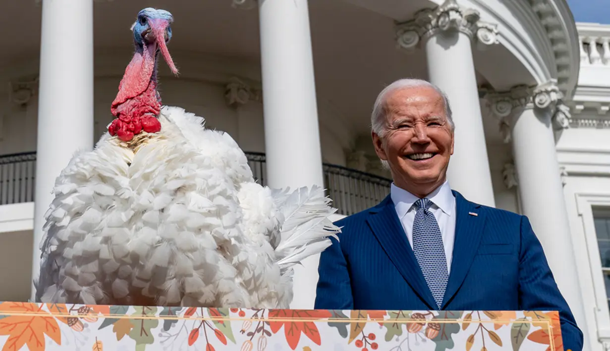 Presiden Amerika Serikat (AS) Joe Biden berdiri di samping Liberty, salah satu dari dua kalkun Thanksgiving nasional, setelah memberikan pengampunan kepada mereka dalam upacara di Halaman Selatan Gedung Putih, Washington, AS, Senin (20/11/2023). (AP Photo/Andrew Harnik)