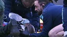 Mateta sempat mendapatkan perawatan di lapangan dan diberikan oksigen sebelum dibawa ke ambulans. (AFP/Glyn Kirk)
