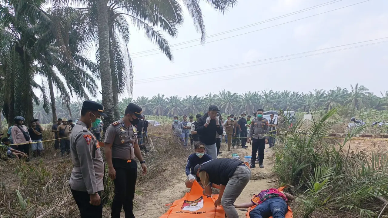 Polisi saat olah TKP dan mengevakuasi jasad wanita yang ditemukan tergeletak dalam kondisi hampir setengah telanjang di Mesuji, Lampung.