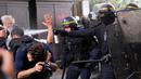 Polisi anti huru-hara menyemprotkan gas ke demonstran dan para fotografer saat terjadi bentrokan di Paris, Prancis (23/5). Para pekerja layanan publik Prancis melakukan pemogakan dan meluas menjadi aksi protes. (AP/Christophe Ena)