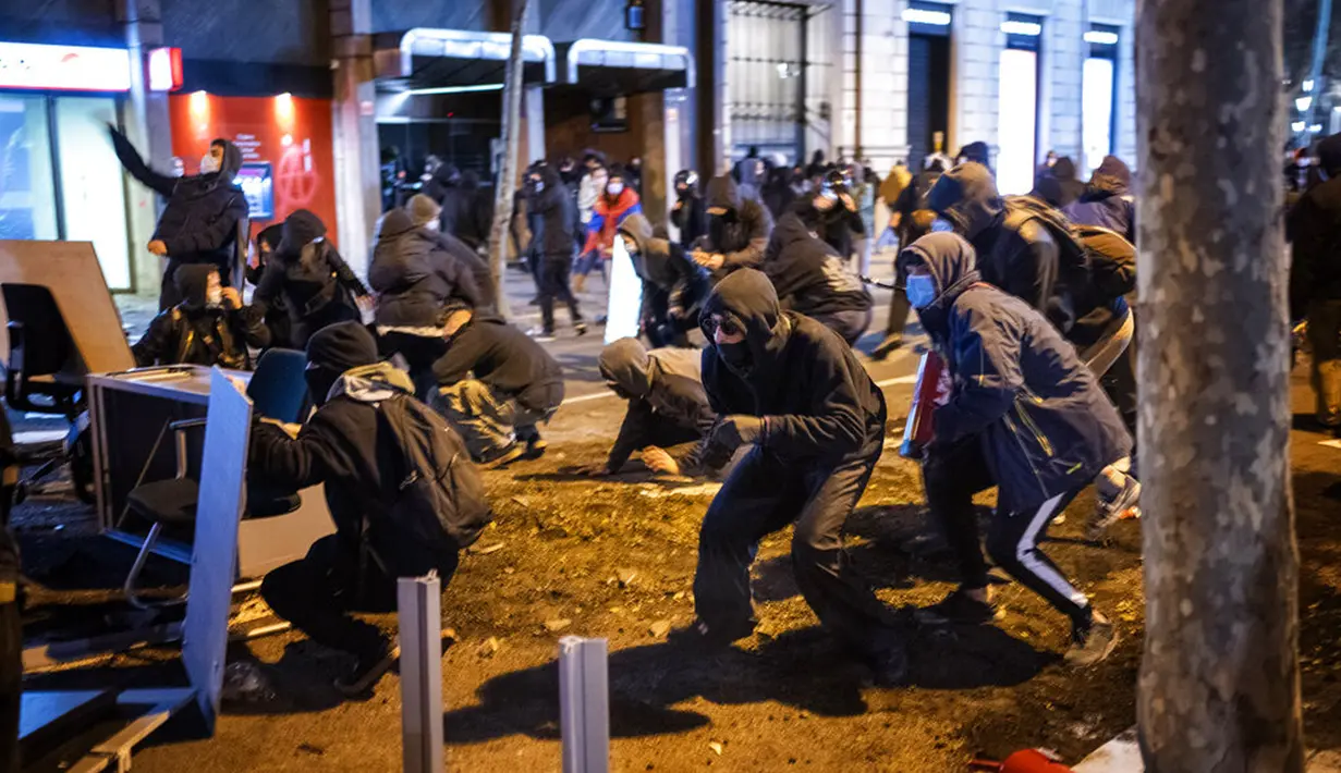 Demonstran bentrok dengan polisi saat memprotes penangkapan rapper Pablo Hasel di Barcelona, Spanyol, Selasa (16/2/2021). Pablo Hasel menggambarkan kasusnya sebagai perjuangan untuk kebebasan berbicara. (AP Photo/Emilio Morenatti)